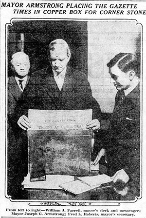 Mayor Armstrong places a newspaper in the time capsule to be buried in the City-County Building.