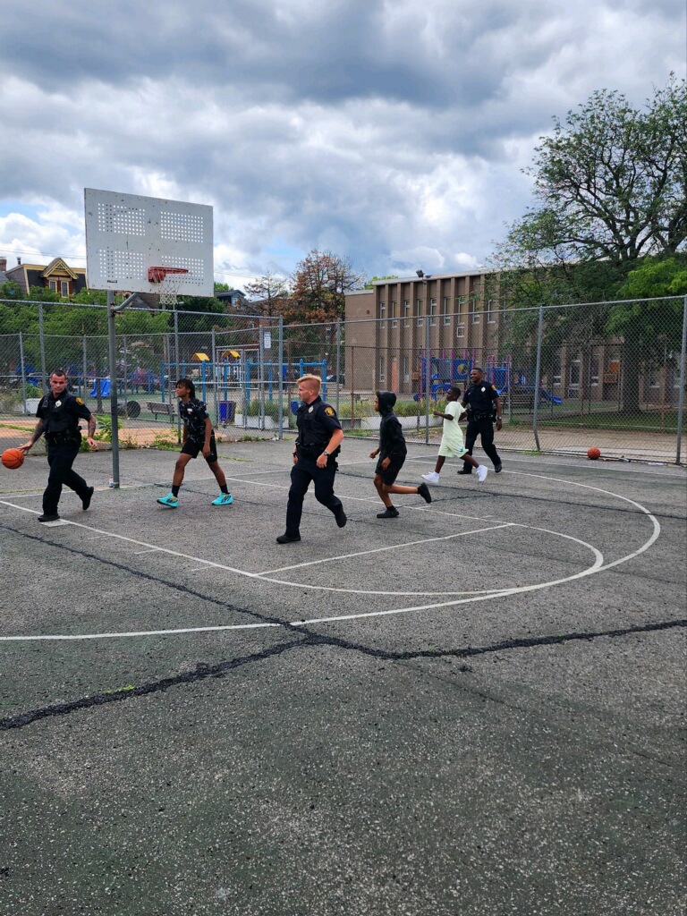 Officers playing basketball with kids