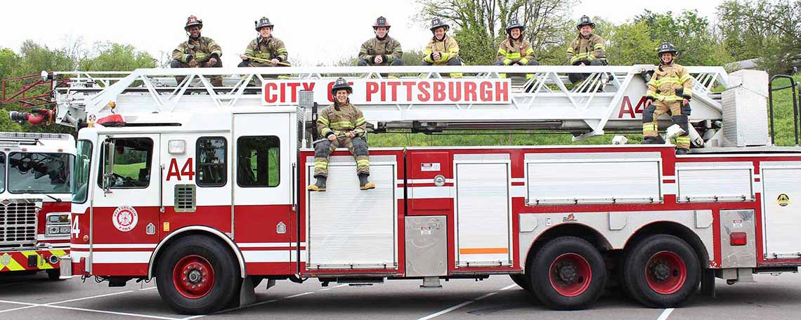 Firefighters sitting on top of Fire Engine.