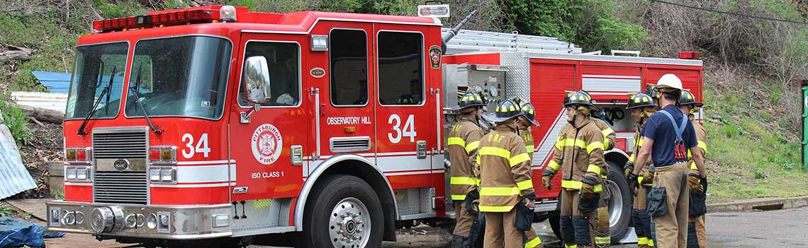 Firefighters grouped around Fire Engine.