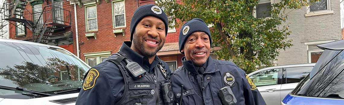 Two police officers smiling for photo.