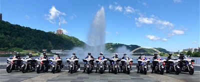 Motorcycle officers with bikes in front of Three Rivers Fountain.