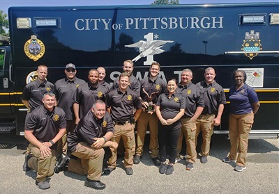 SWATteam posed in front of SWAT van.